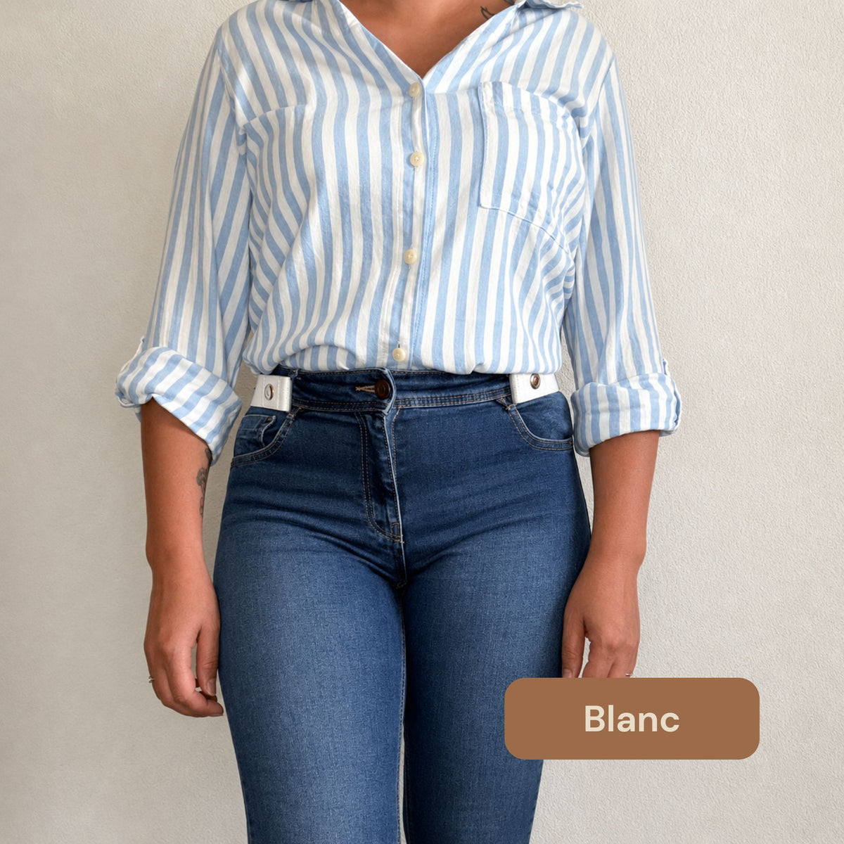 Femme portant la ceinture sans boucle TENELYA blanche avec un jean bleu